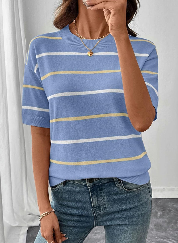 A woman wearing a short-sleeve crewneck knit top with horizontal stripes in light blue, white, and pale yellow, paired with blue jeans.